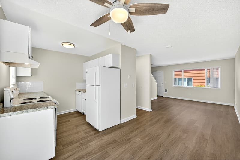 Modern kitchen with white cabinets, granite countertops, and wood floors at Lincoln Court Townhomes in Fairview, Oregon
