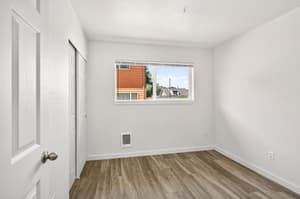 Bedroom with large window, wood flooring at Lincoln Court Townhomes, 230 Lincoln Street, Fairview, Oregon 97024