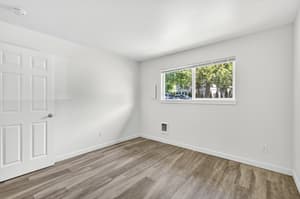 Bedroom with large window, wood floors at Lincoln Court Townhomes, 230 Lincoln Street, Fairview, Oregon 97024