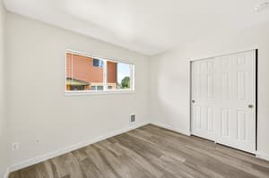 Bedroom with large window, wood floors at Lincoln Court Townhomes, 230 Lincoln Street, Fairview, Oregon 97024