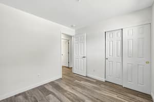 Bright bedroom with wood flooring and fresh paint at Lincoln Court in Fairview, Oregon