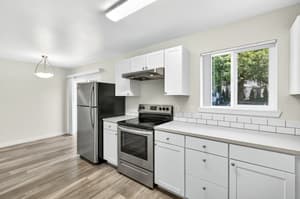 Kitchen with stainless steel appliances, white cabinets at Lincoln Court Townhomes, 230 Lincoln Street, Fairview, Oregon 97024