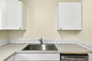 Apartment kitchen with stainless steel sink and modern finishes at Lincoln Court in Fairview, Oregon