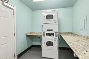 Laundry with stacked washer dryer, granite countertops at Lincoln Court Townhomes, 230 Lincoln Street, Fairview, Oregon 97024