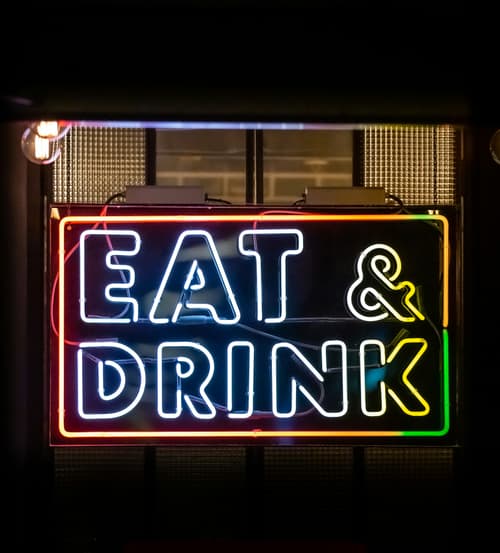Neon Eat & Drink sign glowing at night